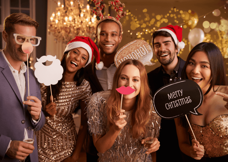 Selfie gép karácsonyi díszítéssel és mosolygós vendégekkel