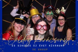 Kollégák ünnepi ruhában pózolnak a tükör selfie gépnél