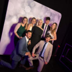Vendégek csoportképet készítenek a Selfie Moments Dream Booth selfie gépével a Wizz Air rendezvényén.